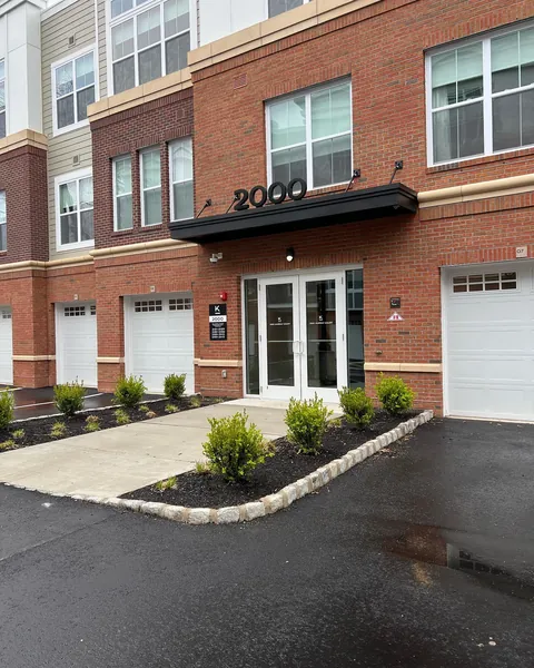 Black aluminum canopy with tie-rod supports above a double-door exterior entry.