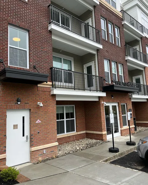 Two black aluminum canopies mounted above separate entries on a red brick building.